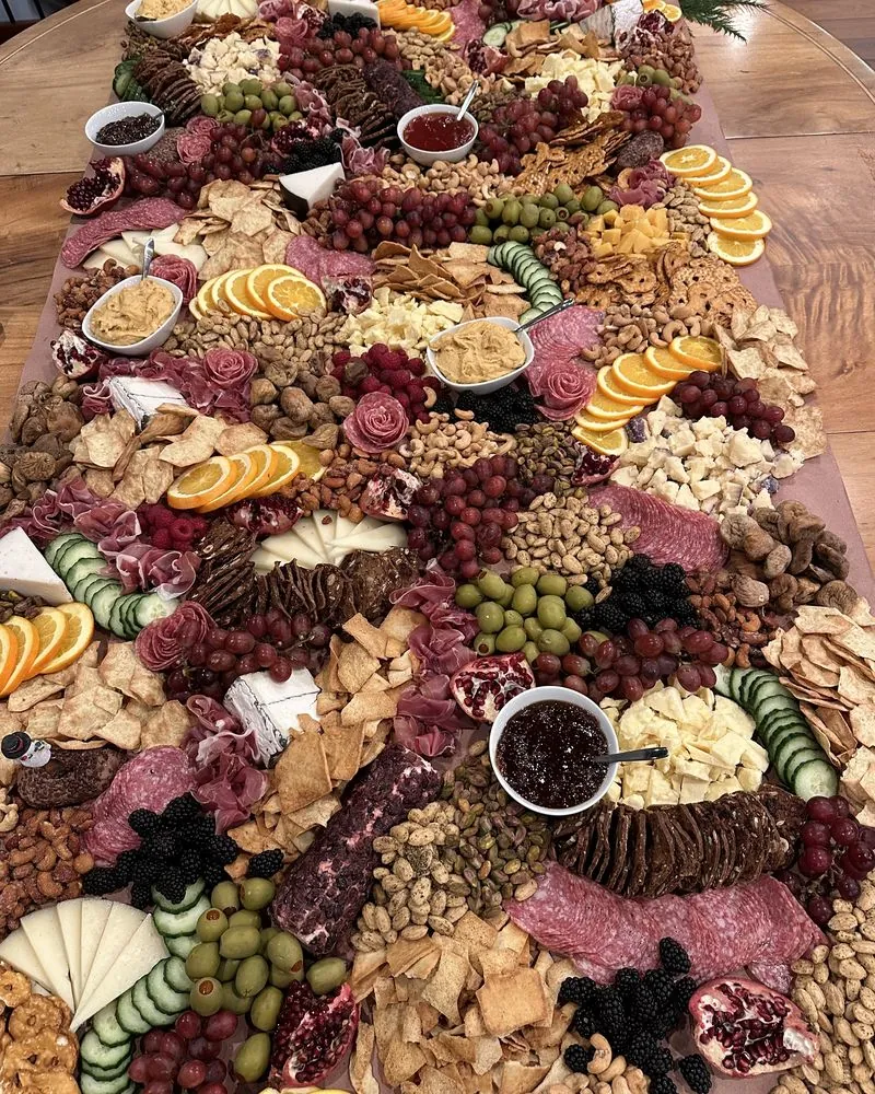 Grazing table covered in charcuterie, fruit, cheese, and crackers