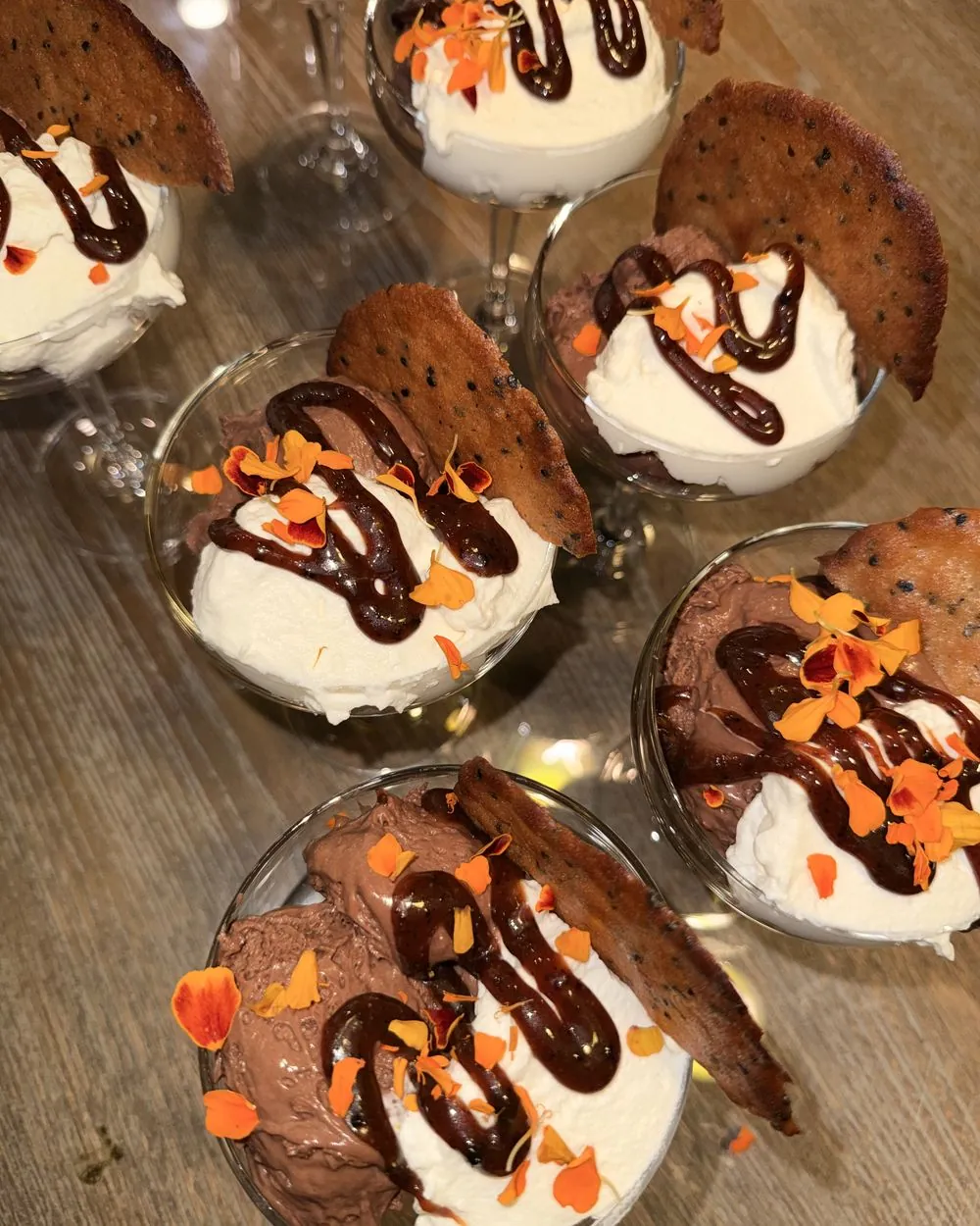 Chocolate mousse cups with whipped cream and edible flowers